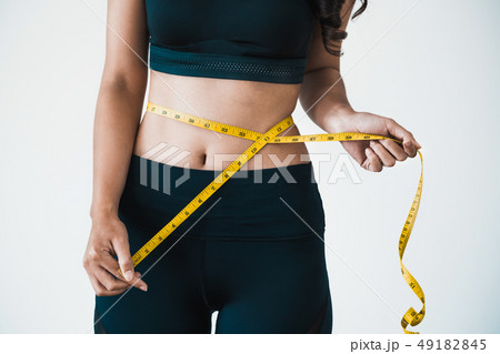 Close up shot woman with slim body measuring torso Close up shot woman with slim body measuring torso 49182845