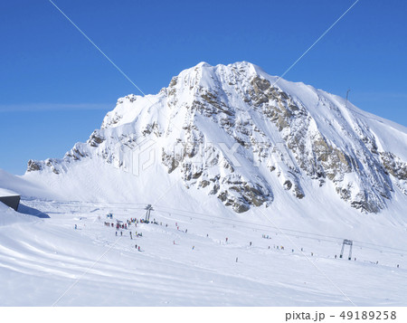 Winter mountains landscape with colorful dressed skiers on white snow slopes. view from the top of 49189258