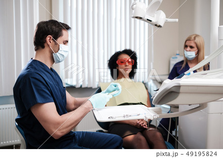 Dentist and his assitant working in private practice 49195824