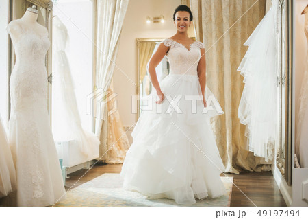 Beautifu bride choosing wedding dress in a wedding salon Beautifu bride choosing wedding dress in a wedding salon 49197494