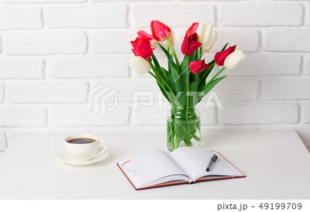tulip flowers are in a vase on the table, cup of 49199709