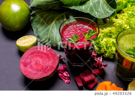 Healthy drink with fruits and vegetables on the black wooden background. 49203326