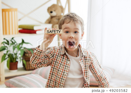 Wooden cubes with word safety in hands of little boy 49203582