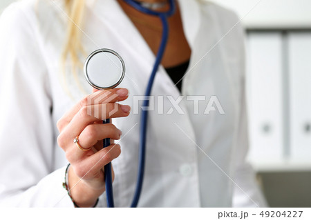 Female medicine doctor hand holding stethoscope head closeup 49204227
