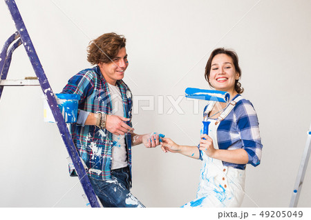 Renovation, redecoration and people concept - Portrait of couple stained with paint over white 49205049