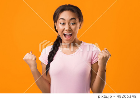 Excited student celebrating success over orange background 49205348
