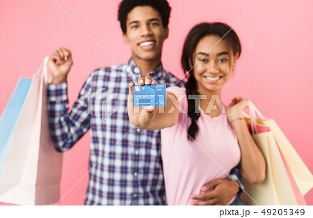 Teenage couple with shopping bags and credit card Teenage couple with shopping bags and credit card 49205349
