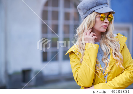 Blonde girl in a yellow raincoat 49205351