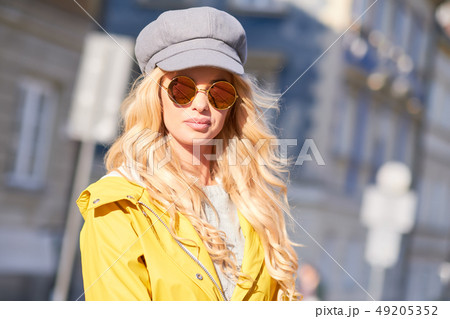 Blonde girl in a yellow raincoat 49205352