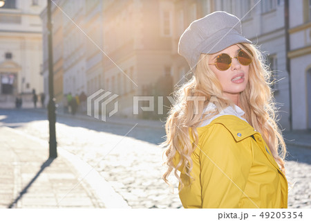 Blonde girl in a yellow raincoat 49205354