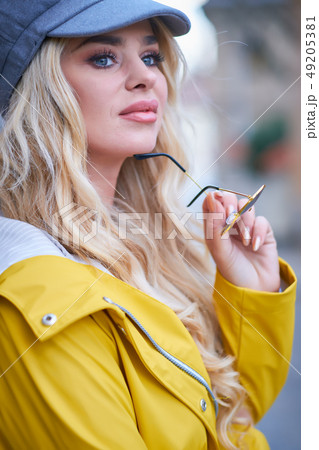 Blonde girl in a yellow raincoat Blonde girl in a yellow raincoat 49205381