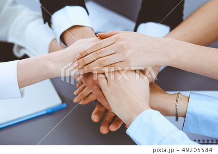 Business people group joining hands and representing concept of friendship and teamwork Business people group joining hands and representing concept of friendship and teamwork 49205584