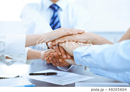 Business people group joining hands and representing concept of friendship and teamwork Business people group joining hands and representing concept of friendship and teamwork 49205604
