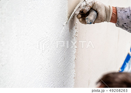 Construction worker plastering and smoothing concrete wall with cement Construction worker plastering and smoothing concrete wall with cement 49208263