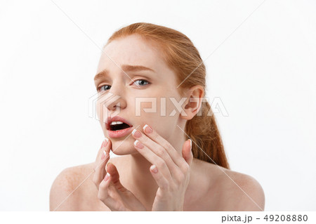 redheaded woman shows fingers on acne on her face. redheaded woman shows fingers on acne on her face. 49208880