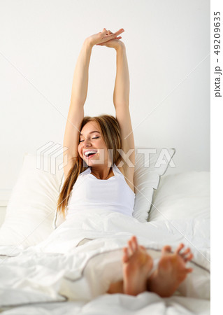 Young beautiful smiling and yawning blonde woman 49209635