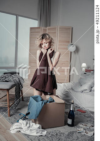 Woman feeling sentimental packing clothes of ex in the bedroom Woman feeling sentimental packing clothes of ex in the bedroom 49211124
