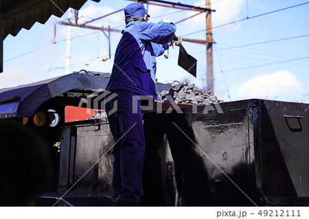 大井川鐵道　SL列車に石炭を積む機関士さん 49212111