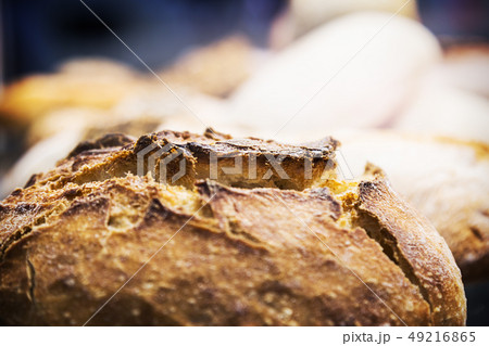 freshly baked loaf of bread with an appetizing crust in the foreground freshly baked loaf of bread with an appetizing crust in the foreground 49216865