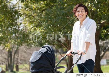 ベビーカーを押す父親 赤ちゃん 公園 散歩 子守り イクメン ベビーカーを押す父親 赤ちゃん 公園 散歩 子守り イクメン 49217862