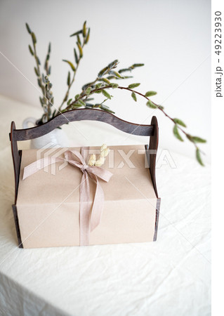 Gift box with spring flowers on light natural fabric background. Easter basket with presents Gift box with spring flowers on light natural fabric background. Easter basket with presents 49223930