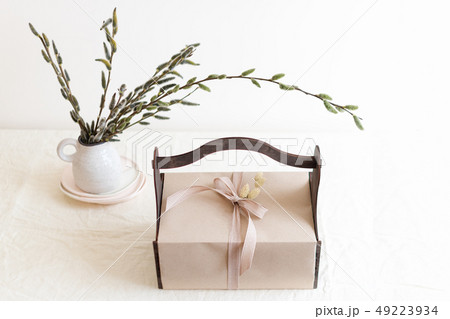 Gift box with spring flowers on light natural fabric background. Easter basket with presents 49223934