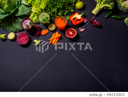 Different healthy vegan drinks with fruits and vegetables on the black wooden background. Flat lay Different healthy vegan drinks with fruits and vegetables on the black wooden background. Flat lay 49224001
