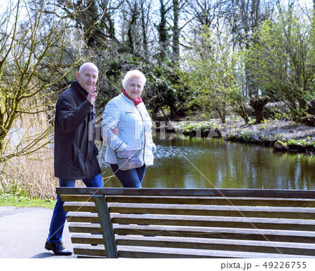 Two seniors seniors walking in spring park Two seniors seniors walking in spring park 49226755