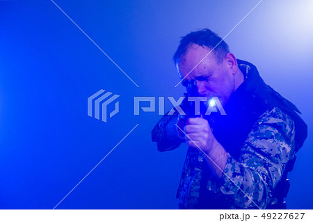 Soldier holding assault rifle in smoky haze Soldier holding assault rifle in smoky haze 49227627