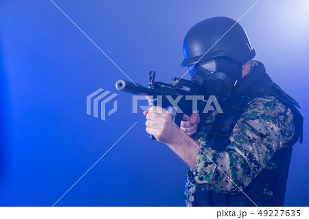 Soldier holding assault rifle in smoky haze 49227635