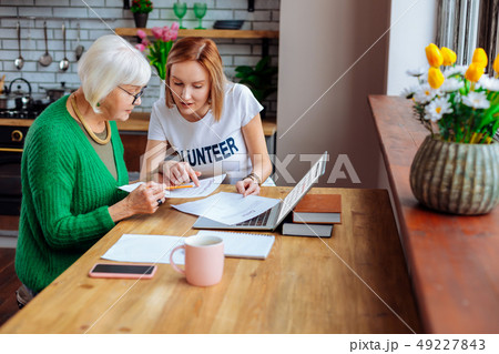 Welfare department worker pointing out at loan items to woman Welfare department worker pointing out at loan items to woman 49227843