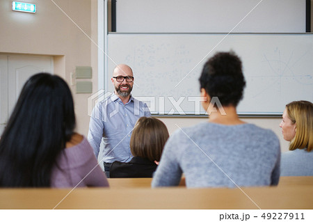 Lecturer and multinational group of students in an auditorium Lecturer and multinational group of students in an auditorium 49227911