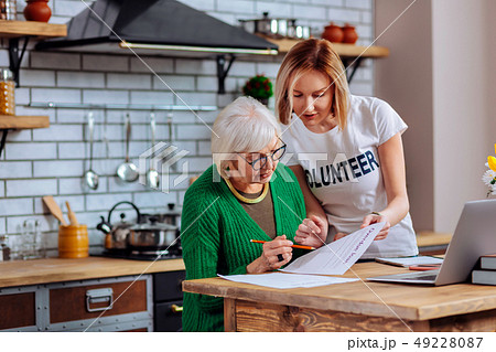 Bewitching volunteer explaining aging woman overdue loan application main points Bewitching volunteer explaining aging woman overdue loan application main points 49228087
