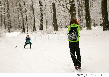 Beautiful happy couple throwing snowballs and having fun in winter park 49230180