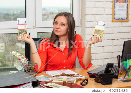 The girl in the office shows bundles of money The girl in the office shows bundles of money 49231486