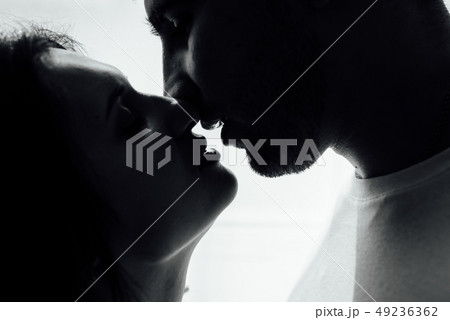 Couple kissing near window. Man and woman in darkness. Sweet taste of your lips 49236362