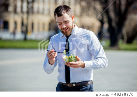 Young businessman in shirt and tie with salad lunch box Young businessman in shirt and tie with salad lunch box 49239370