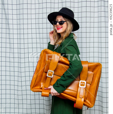 woman in hat and green cloak in 90s style with travel suitcase woman in hat and green cloak in 90s style with travel suitcase 49239625