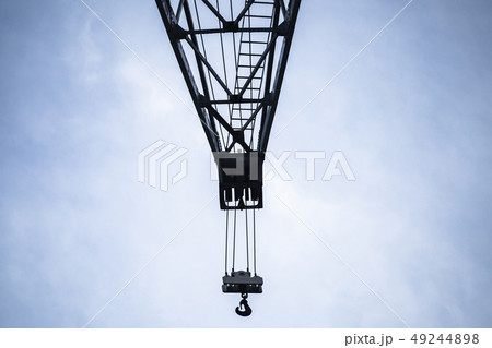 Crane boom with hook under blue sky 49244898
