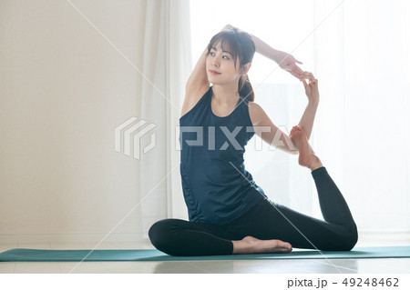 ヨガをする若い女性　日本人　鳩のポーズ　ハトのポーズ　ホットヨガ 49248462