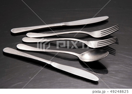 Two silver knives, two forks and a spoon are on the table Two silver knives, two forks and a spoon are on the table 49248625