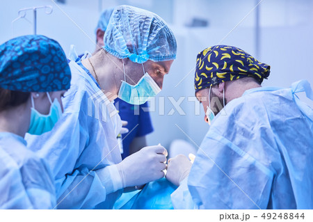 Serious surgeons during a surgery in the hospital. Cross Process 49248844
