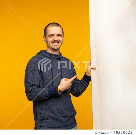 Man holding big white wooden banner and pointing on it Man holding big white wooden banner and pointing on it 49250623