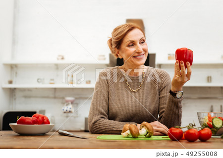 Contented light-haired woman with wide smile lovely looking on pepper 49255008