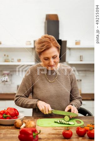 Beaming good-looking in sweater being at home alone and preparing meal 49255094