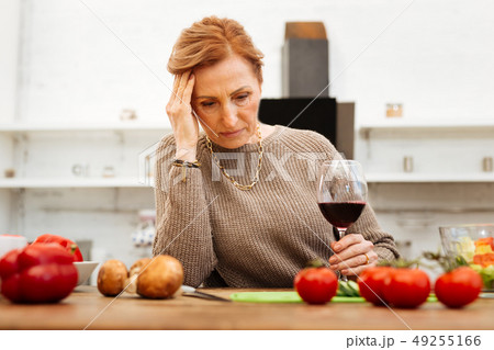 Upset good-looking lady with tied hair wearing warm beige sweater Upset good-looking lady with tied hair wearing warm beige sweater 49255166