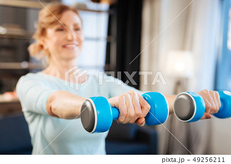 Sportive mature lady having exercises with dumbbells 49256211