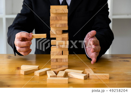 Businessmen picking wood blocks to fill missing 49258204