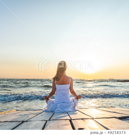 Woman meditating at the sea Woman meditating at the sea 49258373
