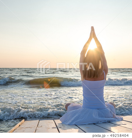 Woman meditating at the sea Woman meditating at the sea 49258404